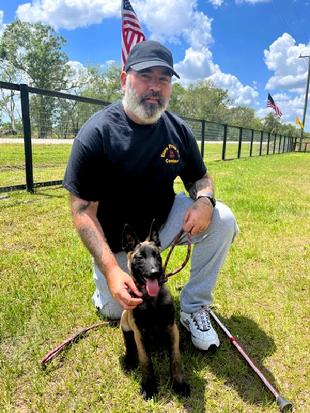 Cedrik Merlet, Euro Pros' Honorary Training Director, with Major, a young male Malinois pup.
